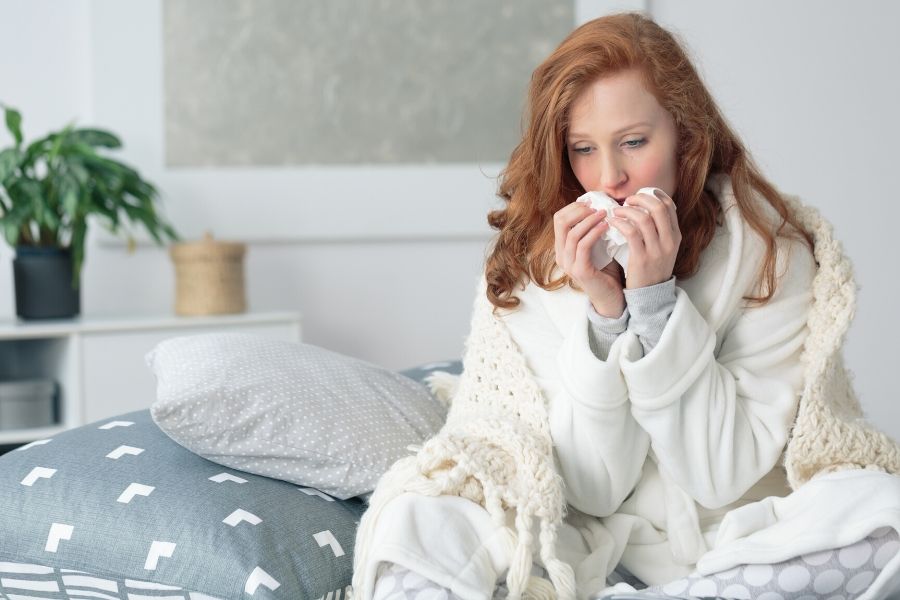 Woman blowing her nose from sinus problems allergies